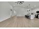 Bright living room features hardwood floors, an open floor plan, kitchen access, and white walls at 9739 Loretto St, Spring Hill, FL 34608