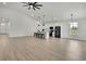 Bright living room features hardwood floors, a modern ceiling fan, an open floor plan, and kitchen access at 9739 Loretto St, Spring Hill, FL 34608