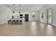 Bright living room with hardwood floors, an open floor plan, kitchen access, and lots of natural light at 9739 Loretto St, Spring Hill, FL 34608