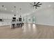 Bright living room with hardwood floors, a modern ceiling fan, an open floor plan, and kitchen access at 9739 Loretto St, Spring Hill, FL 34608