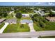 An aerial view of a home featuring lush green lawn, mature trees, and a fenced backyard at 1049 Presque Isle Dr, Port Charlotte, FL 33952