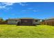 Wide shot of grassy backyard, view of home with enclosed patio and a fence at 1049 Presque Isle Dr, Port Charlotte, FL 33952