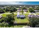 Aerial view showing a home's large, well-maintained lawn, complemented by mature trees and privacy fence at 1049 Presque Isle Dr, Port Charlotte, FL 33952