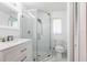 Bright bathroom with glass shower, modern vanity, and white tile at 1049 Presque Isle Dr, Port Charlotte, FL 33952