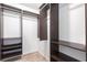 Organized walk-in closet with dark wood shelving and ample hanging space at 1049 Presque Isle Dr, Port Charlotte, FL 33952