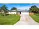 Charming one-story home with well-maintained landscaping, a driveway, and an attached garage at 1049 Presque Isle Dr, Port Charlotte, FL 33952