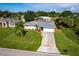 Charming single-story home with a well-manicured lawn, mature trees, and a spacious driveway at 1049 Presque Isle Dr, Port Charlotte, FL 33952