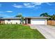 Charming single-story home with a well-maintained lawn and a sunny, blue sky at 1049 Presque Isle Dr, Port Charlotte, FL 33952