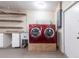 Garage showing red washer and dryer, countertop, utility sink and storage at 1049 Presque Isle Dr, Port Charlotte, FL 33952