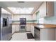 Well-lit kitchen featuring stainless steel appliances, a tile floor, and a skylight at 1049 Presque Isle Dr, Port Charlotte, FL 33952
