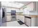 Cozy kitchen featuring stainless steel appliances, white cabinets, and a bright skylight at 1049 Presque Isle Dr, Port Charlotte, FL 33952
