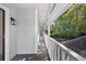 A view of the long back porch featuring wood floors and a painted white railing at 4404 Grainary Ave, Tampa, FL 33624