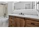 Bathroom featuring a custom wood vanity and a sleek, lighted mirror at 4404 Grainary Ave, Tampa, FL 33624