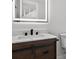 Modern bathroom vanity with wood cabinets, modern faucet, and a lighted mirror at 4404 Grainary Ave, Tampa, FL 33624