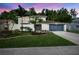 Charming two-story home with blue garage door and landscaped front yard with trees and white brick accents at 4404 Grainary Ave, Tampa, FL 33624