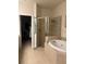 Bathroom featuring a glass shower, a large tub, and tile flooring at 4926 Anniston Cir, Tampa, FL 33647