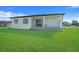 Well-maintained backyard with lush green lawn and stone patio, perfect for entertaining at 3323 Elkcam Blvd, Port Charlotte, FL 33952