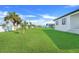 Expansive backyard with green grass and some young trees, offering ample space at 3323 Elkcam Blvd, Port Charlotte, FL 33952
