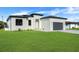 Charming single-Gathering home featuring a spacious driveway, manicured lawn, and a modern garage door at 3323 Elkcam Blvd, Port Charlotte, FL 33952