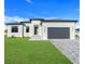 Contemporary single-Gathering home with fresh landscaping and a spacious driveway leading to an attached garage at 3323 Elkcam Blvd, Port Charlotte, FL 33952
