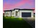 Charming single-Gathering home boasts a modern design with a well-manicured lawn and black garage doors at 3323 Elkcam Blvd, Port Charlotte, FL 33952