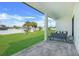 Covered patio with stone tiling, outdoor seating, and a view of the landscaped backyard at 3323 Elkcam Blvd, Port Charlotte, FL 33952