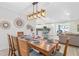 Dining area with wood table set for six, stylish light fixture, and open flow to the kitchen at 4311 123Rd W St, Cortez, FL 34215