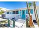 Charming beach house with white brick, aqua door and shutters, and tropical landscaping at 4311 123Rd W St, Cortez, FL 34215