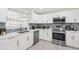 Well-equipped kitchen with white cabinets, stainless steel appliances, and elegant backsplash at 4311 123Rd W St, Cortez, FL 34215