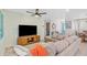 Bright living room with sofa and large TV, leading to a dining area and blue entry door at 4311 123Rd W St, Cortez, FL 34215