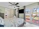 This is a bedroom with a ceiling fan, TV and a door to the outside patio with a hammock at 4311 123Rd W St, Cortez, FL 34215