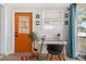 Bright office area with an orange door, glass desk, and coastal decorations at 4311 123Rd W St, Cortez, FL 34215