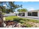 Well-kept backyard with mature trees, partial white fence, and exterior home view at 3410 Allandale Dr, Holiday, FL 34691