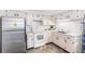 A well-lit kitchen with stainless steel refrigerator, white cabinets, and mosaic tile backsplash at 3410 Allandale Dr, Holiday, FL 34691