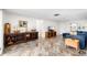 Inviting living room with a comfortable blue sectional, tiled floors, and decorative shelving at 3410 Allandale Dr, Holiday, FL 34691