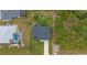 Aerial view of house with an ample backyard and surrounding lush trees and landscaping at 10071 Kingsville Dr, Port Charlotte, FL 33981