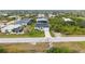 Aerial view showcasing the home's location amidst lush surroundings and neighboring houses at 10071 Kingsville Dr, Port Charlotte, FL 33981