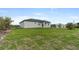 Expansive backyard featuring lush green grass surrounding a modern home with a dark roof at 10071 Kingsville Dr, Port Charlotte, FL 33981