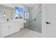 Stylish bathroom with a marble walk-in shower, white vanity, and sleek fixtures at 10071 Kingsville Dr, Port Charlotte, FL 33981