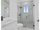 Modern bathroom features marble-look shower and tile floors, a white vanity, and black fixtures at 10071 Kingsville Dr, Port Charlotte, FL 33981