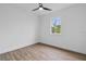 Clean bedroom with wood-look floors, a ceiling fan, a large window, and crisp white paint at 10071 Kingsville Dr, Port Charlotte, FL 33981