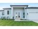 Inviting exterior featuring well-manicured lawn, a modern entryway and a two car garage at 10071 Kingsville Dr, Port Charlotte, FL 33981