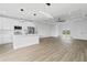 Spacious open-concept living room and kitchen features wood-look floors, modern lighting, and an island with seating at 10071 Kingsville Dr, Port Charlotte, FL 33981