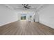 Bright, open-concept living room features wood-look floors, island kitchen, and sliding glass doors to the outdoors at 10071 Kingsville Dr, Port Charlotte, FL 33981
