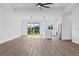Open-concept layout with natural light and wood flooring, seamlessly connects living room to kitchen at 10071 Kingsville Dr, Port Charlotte, FL 33981