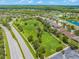 Aerial view featuring a green space with a playground and walking path surrounded by beautiful homes at 10720 Breaking Rocks Dr, Tampa, FL 33647