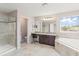 Bright bathroom featuring tiled shower, soaking tub, and double-sink vanity at 10720 Breaking Rocks Dr, Tampa, FL 33647