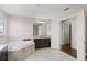 Bright bathroom featuring a soaking tub, dark cabinets and neutral tile flooring at 10720 Breaking Rocks Dr, Tampa, FL 33647