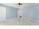 Bedroom featuring neutral carpet, a window, ceiling fan, and freshly painted blue walls at 10720 Breaking Rocks Dr, Tampa, FL 33647