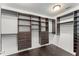 Walk-in closet with custom dark wood shelves, drawers, and ample storage space at 10720 Breaking Rocks Dr, Tampa, FL 33647